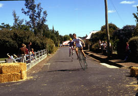 Cyclists sprint on penny farthing bicycles