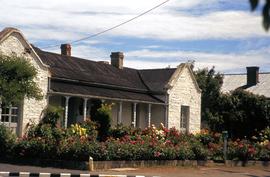 Rendered stone house with extensive floral garden