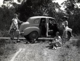 Occupants of motor vehicle step outside car on bush track