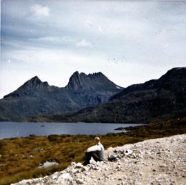 Man sitting on gravel near Cradle Mountain