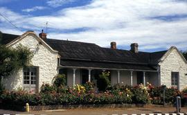 Rendered stone house at Bellerive with large floral garden