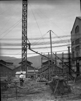 Concrete pouring tower hoisted at E.Z. Co. Zinc Works